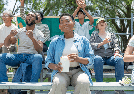 People sitting on bleachers, smiling and cheering